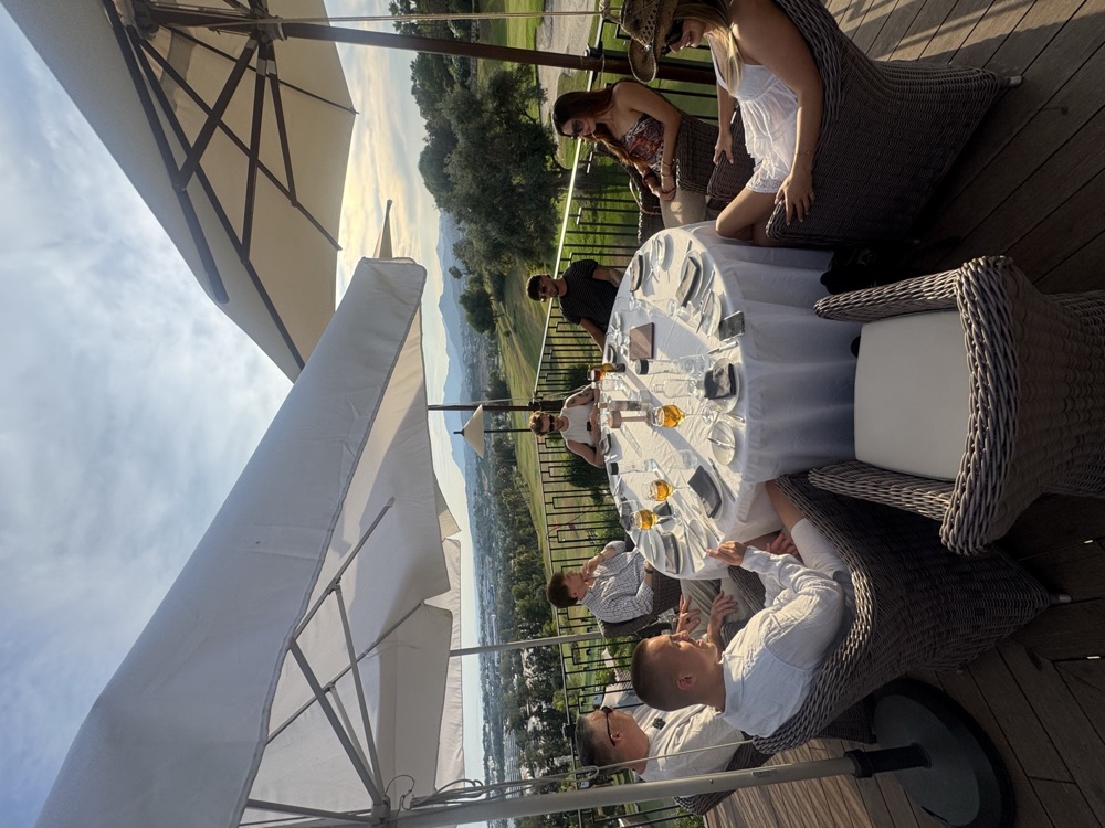 Group dinner under umbrellas at golden hour